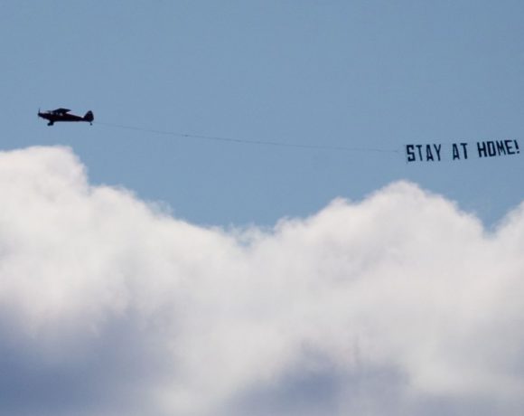 No início da primavera européia, um avião sobrevoa Hamburgo, na Alemanha, pedindo as pessoas para que fiquem em casa. (foto DPA)